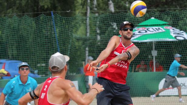 epa03776442 Clemens Doppler (R) and Alexander Horst (L) from Austria during the match with Juan Virgen/ Lombardo Ontiveros (Mexico) at the Beach Volleyball World Championships 2013 in Stare Jablonki, Poland, 05 July 2013. EPA/TOMASZ WASZCZUK POLAND OUT