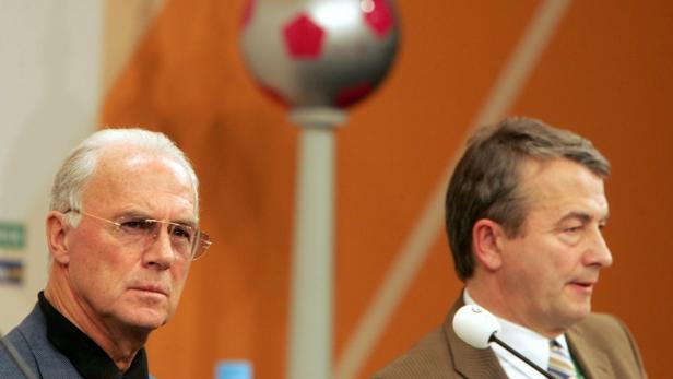 Franz Beckenbauer bei einer Pressekonferenz neben einem weiteren Mann.