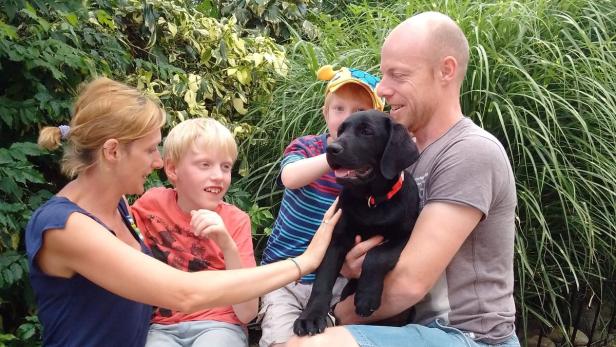 Linus mit seiner Familie und dem schwarzen Hund Deni