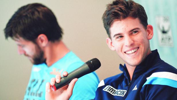 Dominic Thiem lächelt in die Kamera und hält ein Mikrofon.