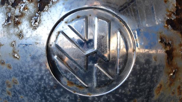 Das VW-Logo auf einer verrosteten Oberfläche.