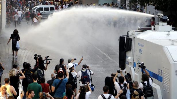 epa03794821 Turkish riot police use water cannon to disperse protestors during an anti government protest at Taksim Square in Istanbul, Turkey 20 July 2013. EPA/JIWAN GUNER