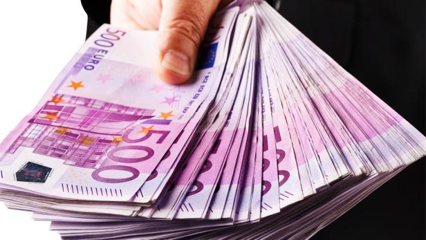 Ein Manager mit vielen 500 Eurogeld Scheinen in der Hand.