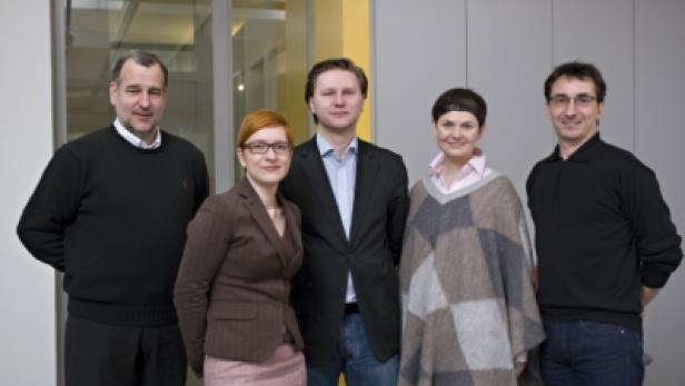 Fünf Personen posieren für ein Gruppenfoto in einem Büro.