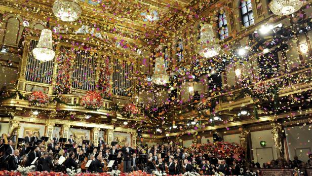Das Wiener Neujahrskonzert im goldenen Saal mit einem Orchester und Konfetti in der Luft.
