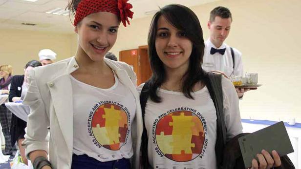 Zwei junge Frauen tragen T-Shirts mit dem Aufdruck „Accepting and Celebrating Diversity“.