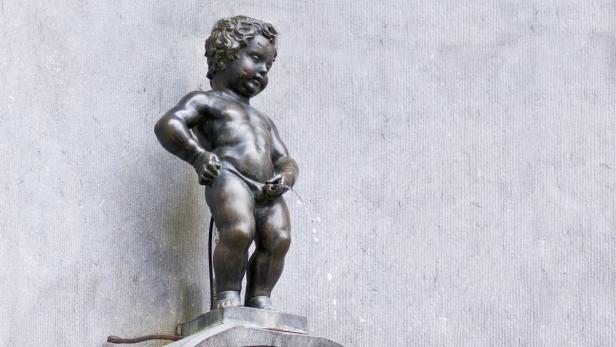 Die Bronzestatue des Manneken Pis in Brüssel uriniert.