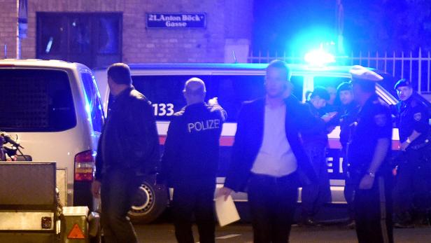 Polizeibeamte stehen vor einem Einsatzfahrzeug in der Anton-Böck-Gasse.