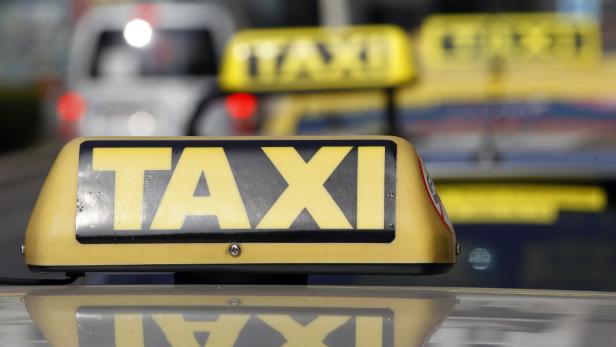 Ein gelbes Taxi-Schild auf dem Dach eines Autos.