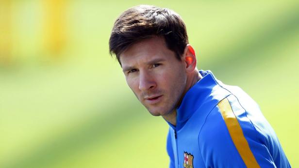 Lionel Messi in einem blauen Trainingsanzug vor einem grünen Hintergrund.
