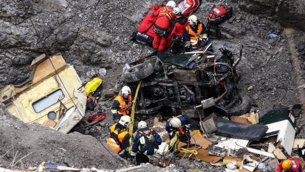 Rettungskräfte arbeiten an der Bergung eines verunglückten Fahrzeugs in einem Geröllfeld.