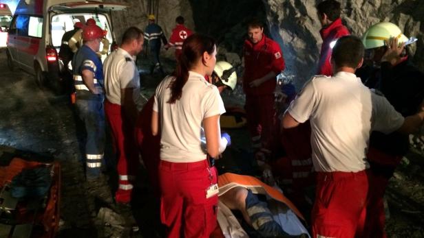 Rettungskräfte versorgen eine verletzte Person in der Nähe eines Krankenwagens.