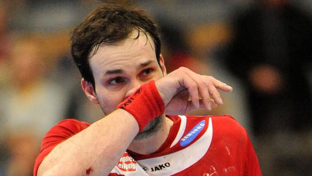 Ein Handballspieler wischt sich den Schweiß von der Stirn.