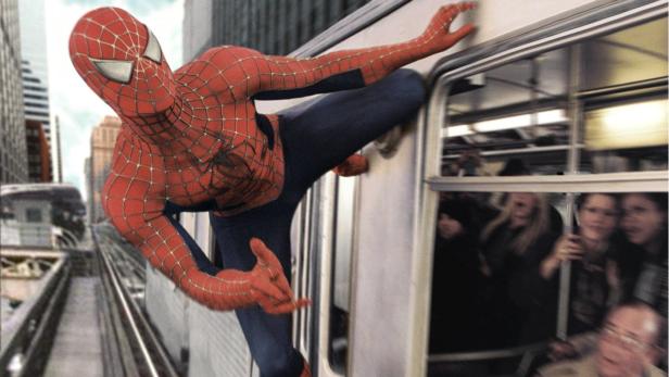 Spider-Man klammert sich an die Außenseite einer U-Bahn.