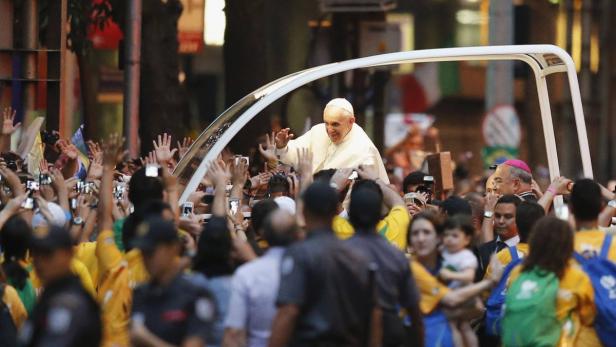 Pope Francis greets the crowd of faithful from his popemobile in downtown Rio de Janeiro, July 22, 2013. Pope Francis touched down in Rio de Janeiro on Monday, starting his first foreign trip as pontiff and a weeklong series of events expected to attract more than a million people to a gathering of young faithful in Brazil, home to the world&#039;s largest Roman Catholic population. REUTERS/Sergio Moraes (BRAZIL - Tags: RELIGION POLITICS)