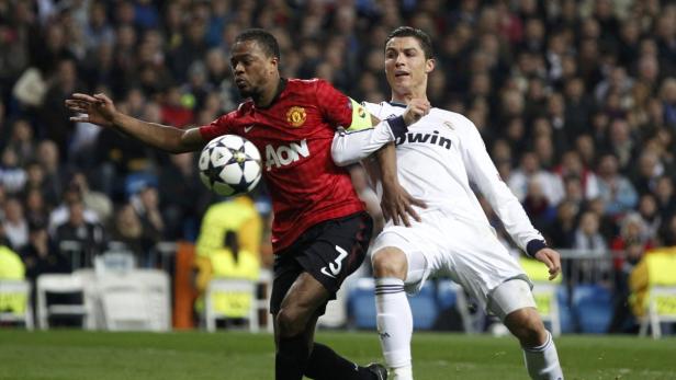 Manchester United&#039;s Patrice Evra (L) is held by Real Madrid&#039;s Cristiano Ronaldo during their Champions League soccer match at Santiago Bernabeu stadium in Madrid February 13, 2013. REUTERS/Paul Hanna (SPAIN - Tags: SPORT SOCCER)