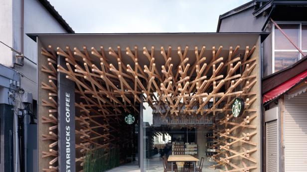 Kaffee wie überall, Architektur wie nirgendwo: Kengo Kuma realisierte in Japan eine für  &quot;Starbucks&quot; recht untypische Filiale. Für die Innenraumgestaltung kreuzte er mehr als 2000 Holzstöcke, die von Innen nach Außen dringen und dem Eingang und der Fassade einen skulpturalen Auftritt verleihen.