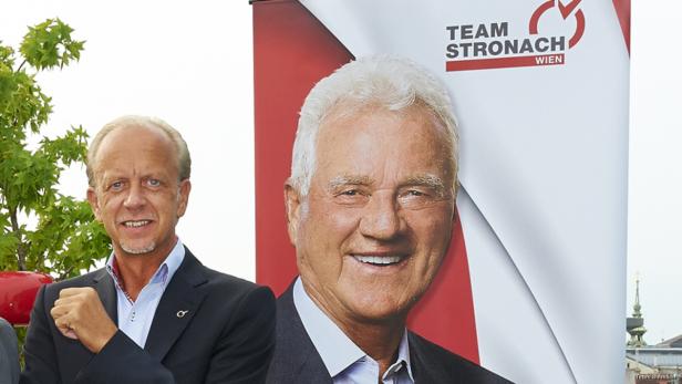 Ein Mann steht neben einem Wahlplakat von Frank Stronach, Team Stronach Wien.