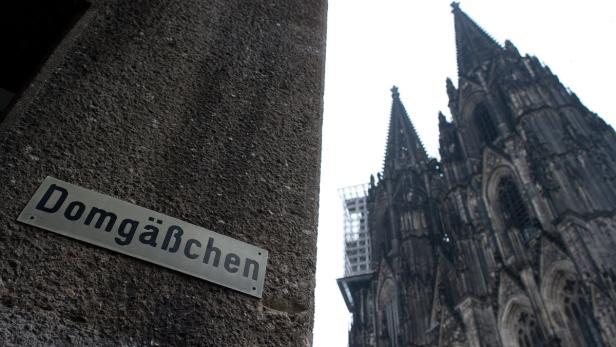 Ein Schild mit der Aufschrift „Domgäßchen“ vor dem Kölner Dom.