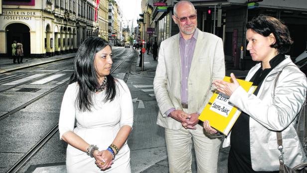 Drei Personen stehen auf einer Straße in Wien, eine Frau hält eine Mappe mit der Aufschrift „Rettet Steffl-Blick“.