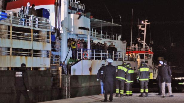 Die „Ezadeen“ liegt vor Anker, während Rettungskräfte und Migranten an Land gehen.