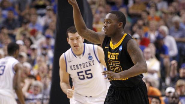 West Virginia Mountaineers guard Darryl Bryant (R) celebrates after scoring as Kentucky Wildcats forward Josh Harrellson looks on during their third round NCAA basketball game in Tampa, Florida March 19, 2011. REUTERS/Scott Audette (UNITED STATES - Tags: SPORT BASKETBALL)