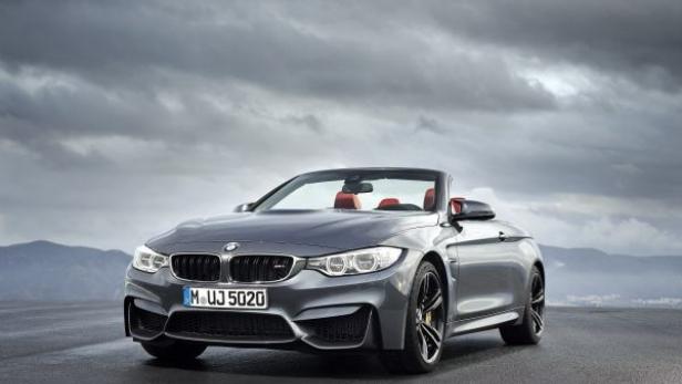 Ein graues BMW M4 Cabriolet vor einem bewölkten Himmel.