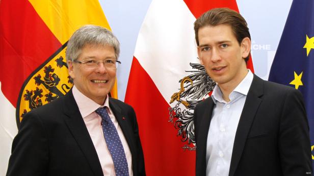 Sebastian Kurz und ein weiterer Mann posieren vor Flaggen Österreichs und der EU.