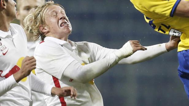 Ein Fußballspieler verzieht schmerzhaft das Gesicht während eines Spiels.
