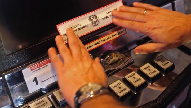 Eine Person spielt an einem Spielautomaten, der von der Finanzpolizei versiegelt wurde.