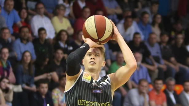 Ein Basketballspieler zielt auf den Korb, um einen Wurf auszuführen.