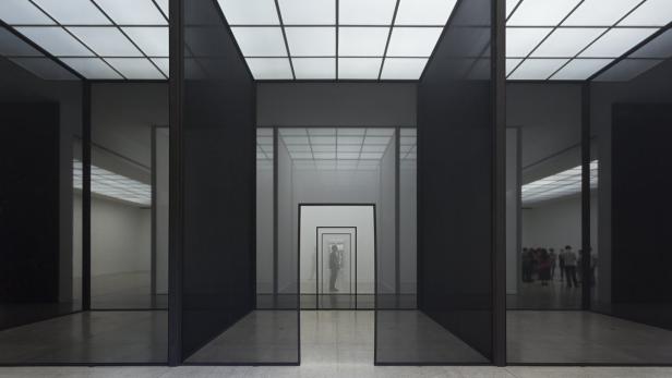 Ein Museumsraum mit einer Reihe von schwarzen Rahmen, die einen perspektivischen Tunnel bilden.