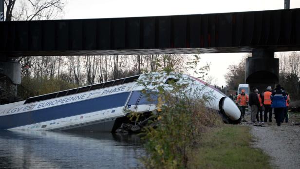 Ein verunglückter TGV-Zug liegt teilweise im Wasser unter einer Brücke.