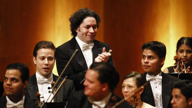 Venezuelan conductor Gustavo Dudamel greets musicians before he prepares to lead the Simon Bolivar Symphonic Orchestra during a concert at Teresa Carreno theater in Caracas July 20, 2012. REUTERS/Carlos Garcia Rawlins (VENEZUELA - Tags: SOCIETY ENTERTAINMENT)