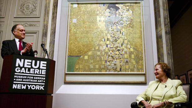 Ein Mann applaudiert neben Gustav Klimts „Adele Bloch-Bauer I“, während eine Frau daneben sitzt.