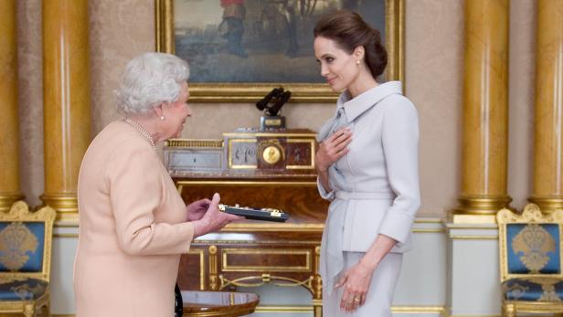Königin Elisabeth II. überreicht Angelina Jolie eine Auszeichnung.