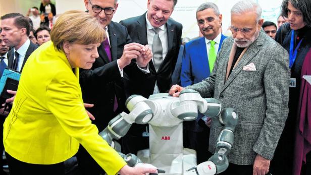 ABB-Chef Spiesshofer (2.v.li.) konnte auch Kanzlerin Merkel den Roboter YuMi vorführen.