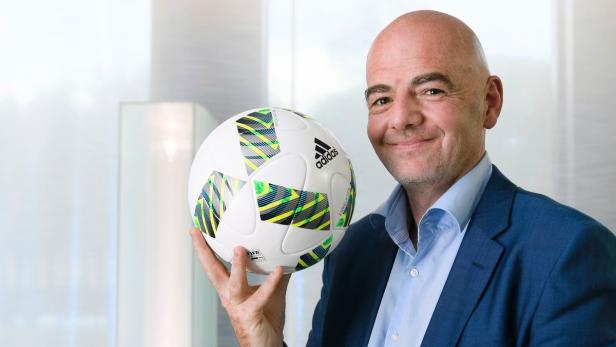 Gianni Infantino hält einen Adidas-Fußball in der Hand.