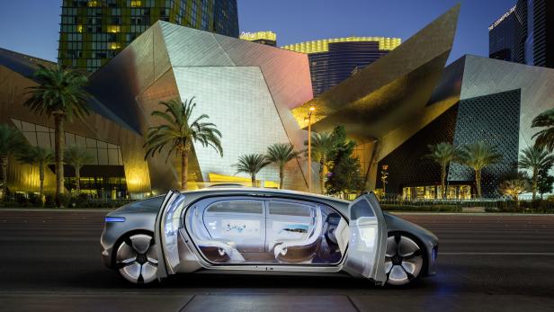 Ein futuristisches Auto mit geöffneten Türen vor einer modernen Stadtkulisse.