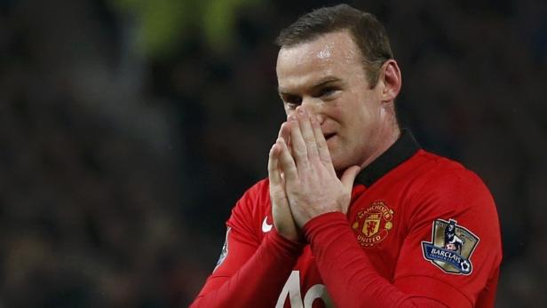 Wayne Rooney, im roten Trikot von Manchester United, hält die Hände vors Gesicht.