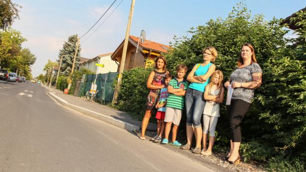 Eine Gruppe von Frauen und Kindern steht am Straßenrand.
