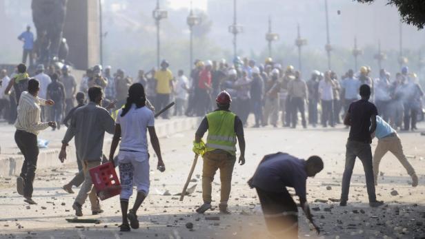 Members of the Muslim Brotherhood and supporters of ousted Egyptian President Mohamed Mursi (back) clash with anti-Mursi protesters, along Qasr Al Nil bridge, which leads to Tahrir Square, in Cairo July 22, 2013. Supporters and opponents of ousted Egyptian President Mohamed Mursi clashed in central Cairo on Monday, hurling stones and firing birdshot and fireworks at each other, witnesses said. REUTERS/Stringer (EGYPT - Tags: POLITICS CIVIL UNREST)