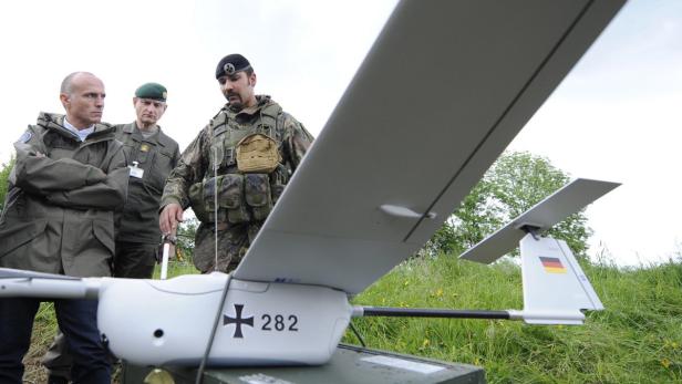 epa03722638 A German soldier (R) gives explanations on an aerial drone to Austrian army chief Othmar Commenda (L) and Austrian Defense Minister Gerald Klug (C) during the military exercise &#039;Eurad13&#039; in Allensteig, Austria, 29 May 2013. EPA/HANS KLAUS TECHT