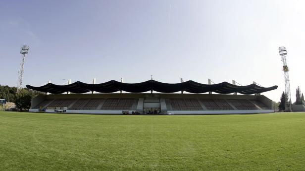 Ein Fußballstadion mit Rasenfläche und überdachter Tribüne.