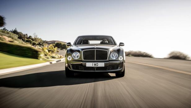 Ein grauer Bentley fährt auf einer Landstraße.
