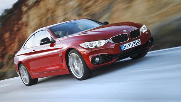 Ein roter BMW fährt auf einer Landstraße.