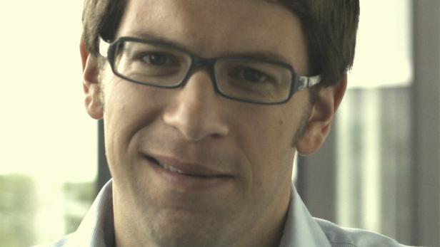 Ein Mann mit Brille lächelt in die Kamera.