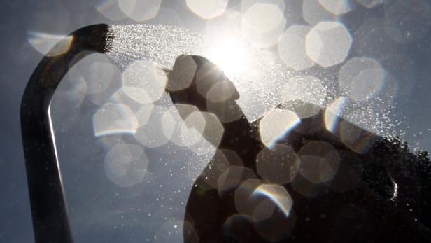 Eine Junge steht am 18.06.2013 im Freibad in Lingen (Niedersachsen) unter einer Dusche. Drei Tage vor dem astronomischen Sommeranfang und neun Tage vor den Sommerferien in Niedersachsen zeigt sich das Wetter mit heißen Temperaturen von über 30-Grad Celsius. Foto: Friso Gentsch/dpa +++(c) dpa - Bildfunk+++