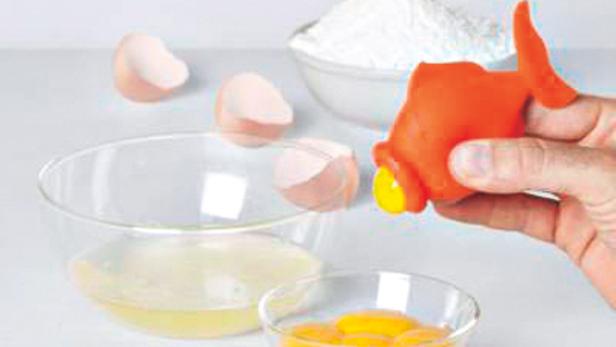 Ein Eigelb wird mit einem orangefarbenen Hilfsmittel von Eiweiß getrennt.