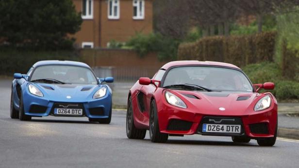 Ein roter und ein blauer Lotus Elise fahren auf einer Straße.